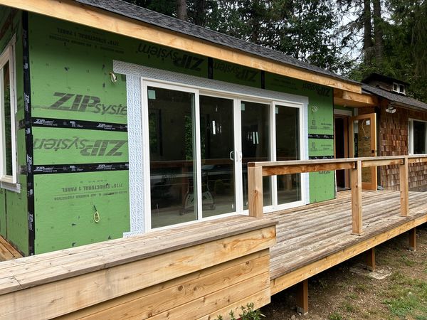 Tiny home under construction with ZIP System sheathing, sliding doors and a new deck